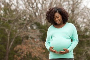 Pregnant Woman Smiling and Holding Her Belly